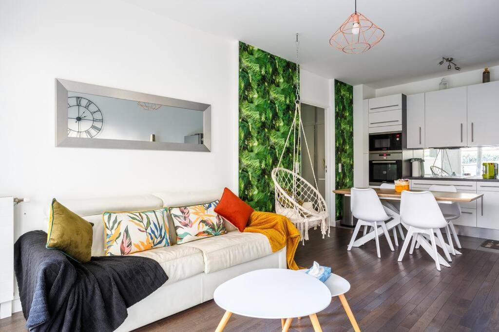 a living room with a couch and a table and a kitchen at Apt 6P - Standing RER Tram Paris Orly Velizy in Le Plessis-Robinson
