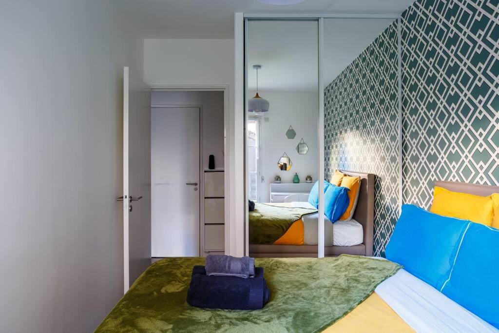 a bedroom with a bed with a large mirror at Apt 6P - Standing RER Tram Paris Orly Velizy in Le Plessis-Robinson