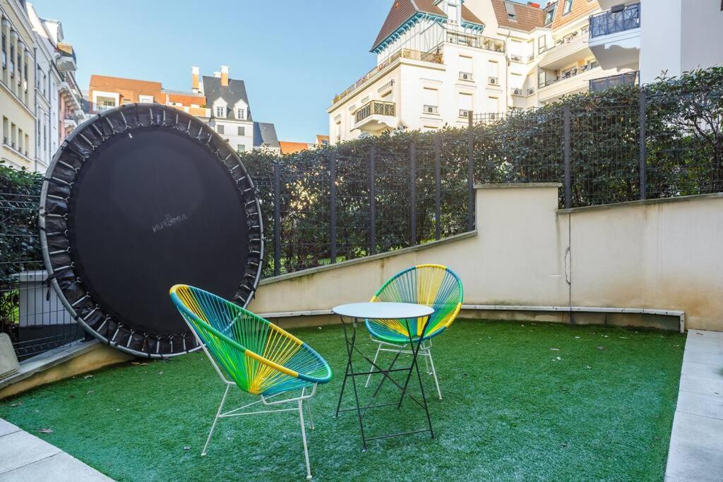 two chairs and a table and a giant target on a patio at Apt 6P - Standing RER Tram Paris Orly Velizy in Le Plessis-Robinson