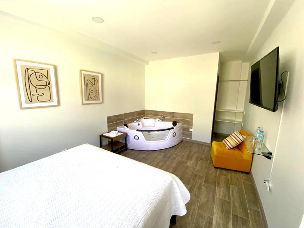 um quarto com uma cama e uma banheira em AHAVAH SUITES em Baños
