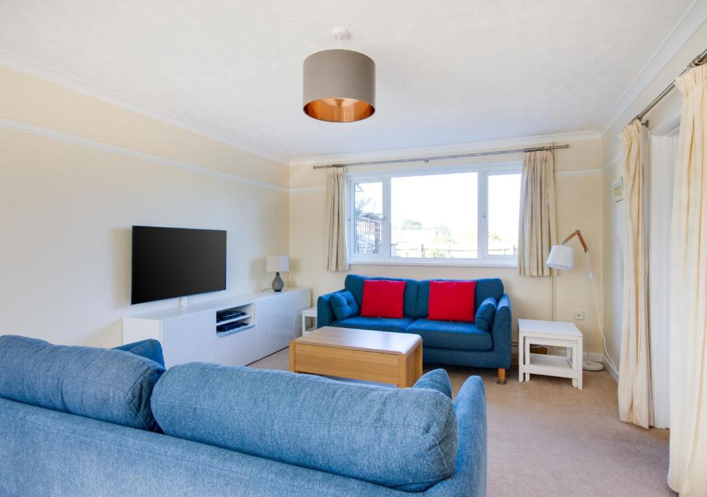 謝林漢姆的住宿－3 Hilbre Court，客厅配有蓝色的沙发和电视