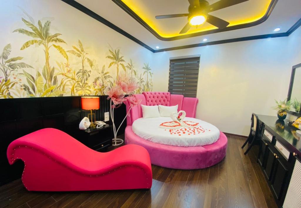 a bedroom with a pink bed and a red couch at Thanh Cong Hotel Ha Long in Ha Long