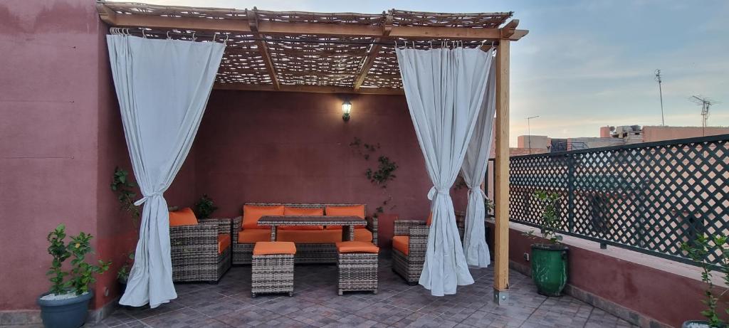 a patio with a table and chairs on a balcony at Marrakech medina inn in Marrakesh