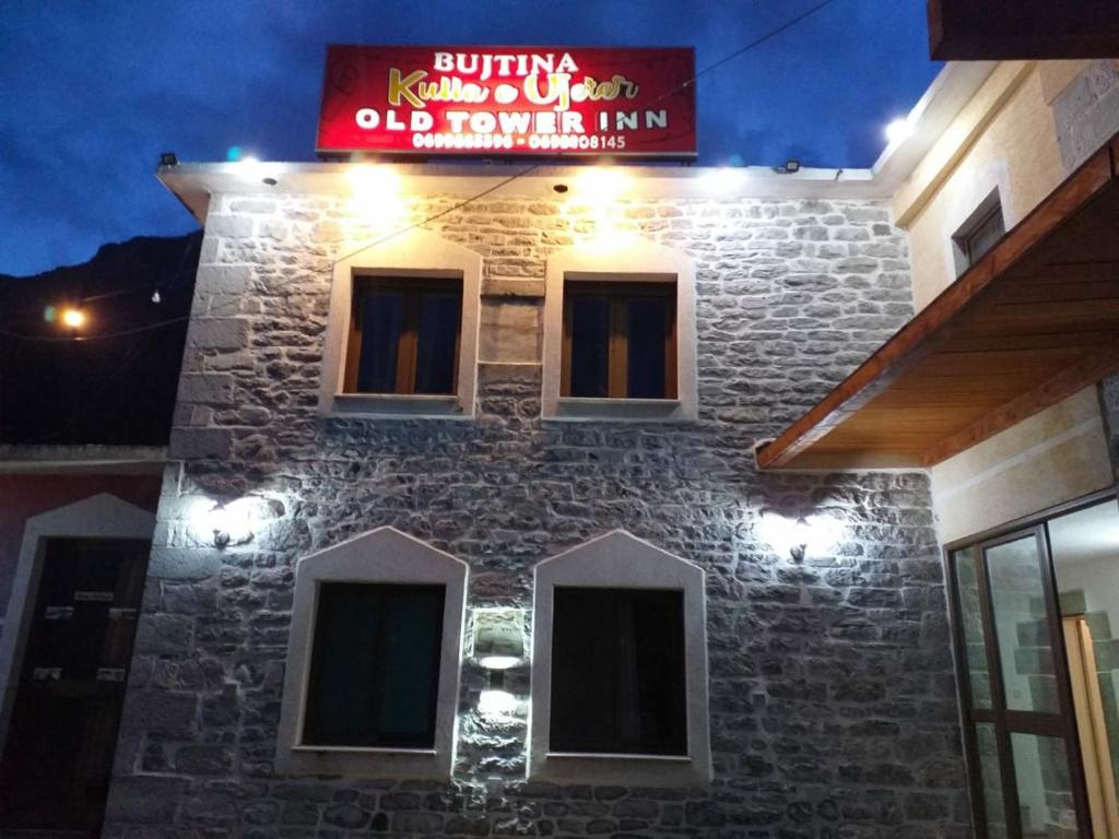 um edifício de tijolos com um sinal em cima em Kulla e Vjeter (Bar Restaurant, Guesthouse, Parking and Camping) em Koman