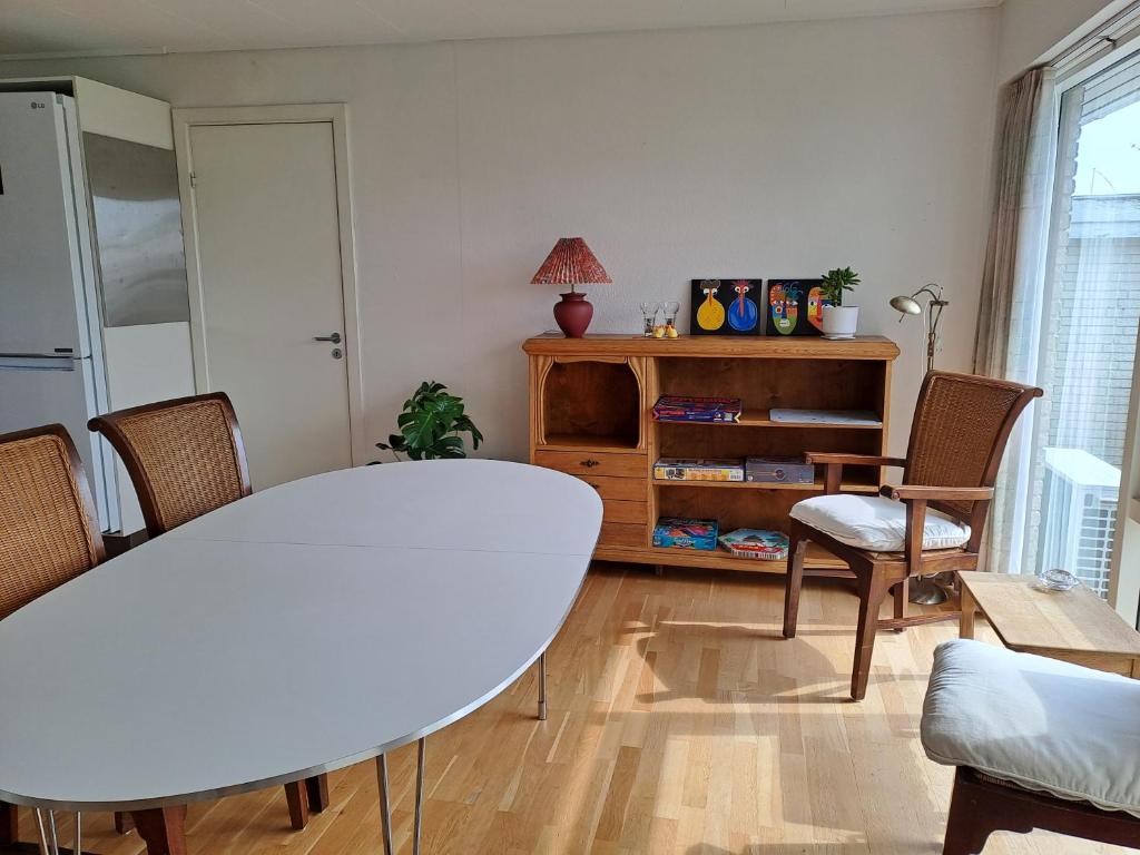 VindPust في فاردي: غرفة معيشة مع طاولة وكراسي بيضاء