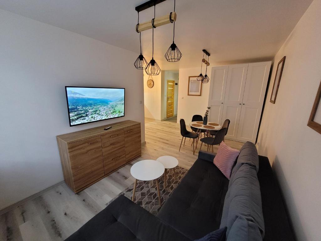 a living room with a couch and a flat screen tv at Apartament Ślęczka in Zabrze