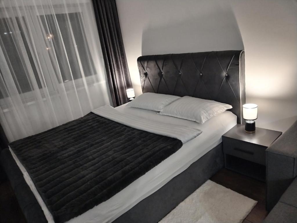 una camera da letto con un grande letto con una grande finestra di Apartman 007 a Kragujevac