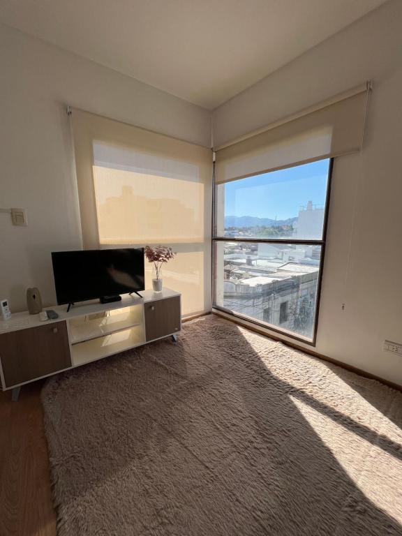 een woonkamer met een flatscreen-tv en een groot raam bij TRESOR TReS in San Luis