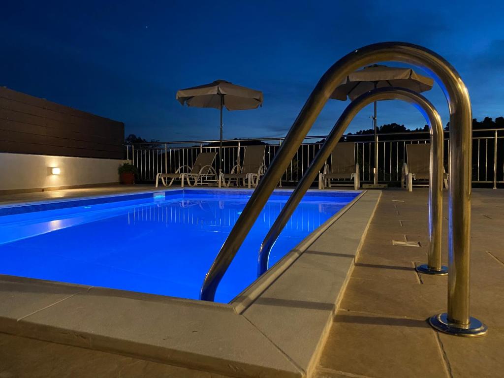 una piscina por la noche con sombrilla en Villa Valmas, en Skiathos
