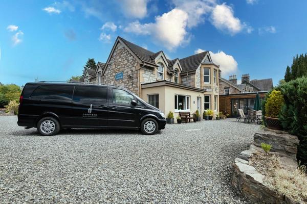 una furgoneta negra estacionada frente a una casa en Derrybeg Bed and Breakfast, en Pitlochry