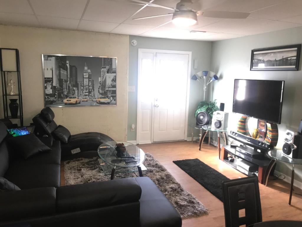 a living room with a couch and a tv at Your Getaway Home / Finished Basement Private Entry in Palmetto
