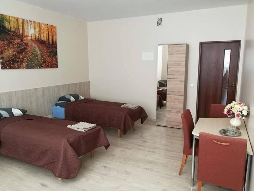 ein Hotelzimmer mit 2 Betten und einem Tisch in der Unterkunft MUSKATAS in Rietavas