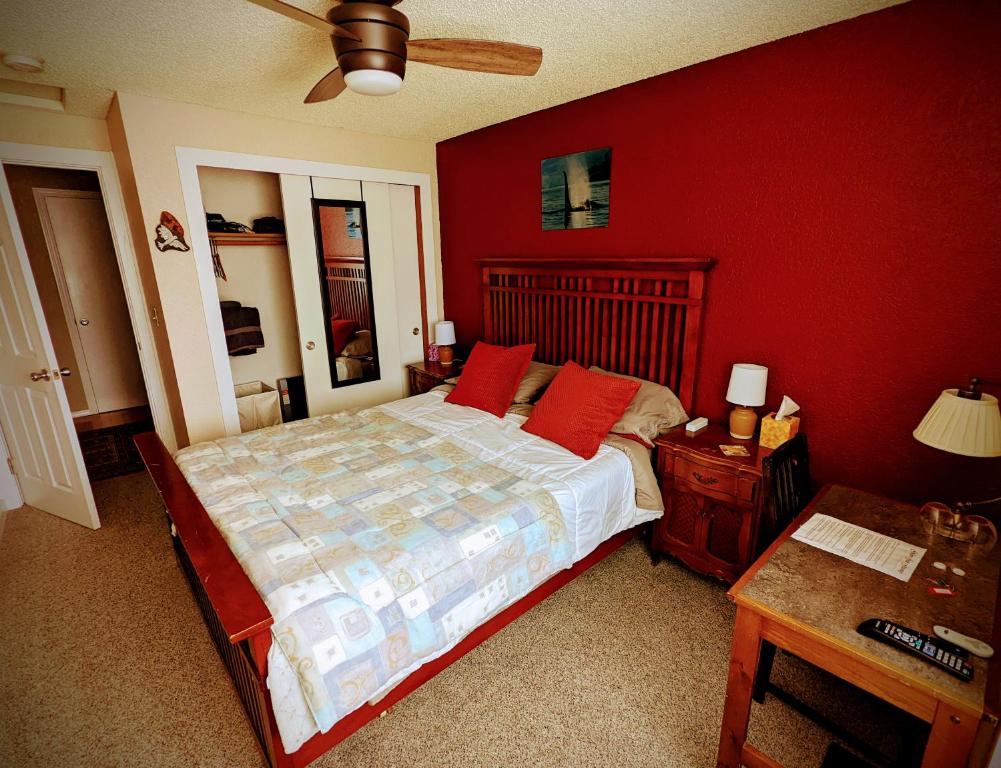 um quarto com uma cama e uma parede vermelha em Golden Gate Getaway em Fircrest