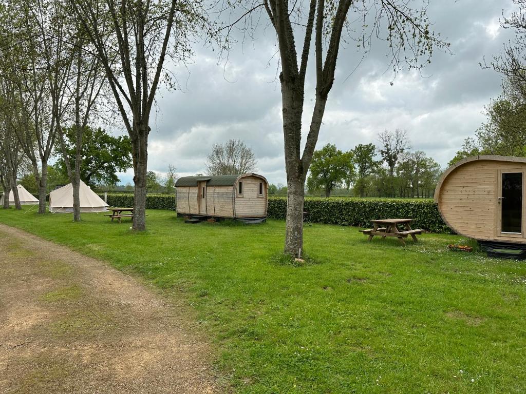 a group of tents and picnic tables in a field at Camping de Messeugne 