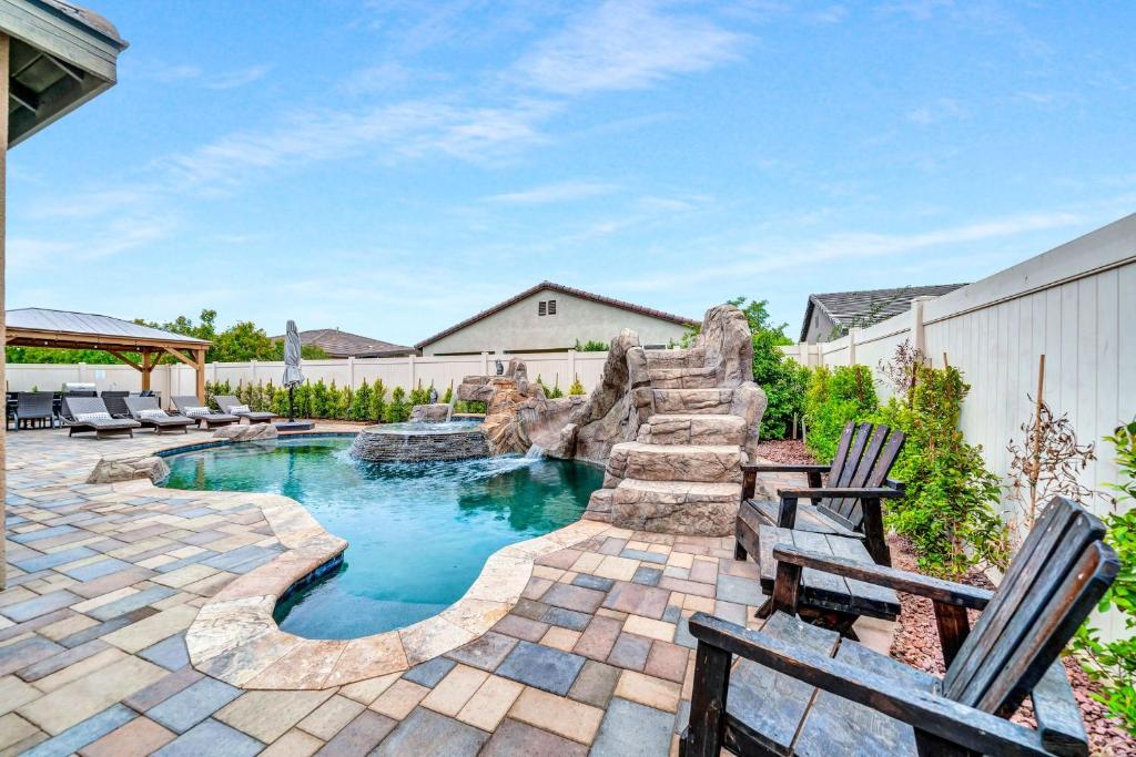 a swimming pool with a waterfall in a backyard at IndioStay with private Pool, Water Slide, Waterfall, Jacuzzi and Fire Pit near Coachella in Indio