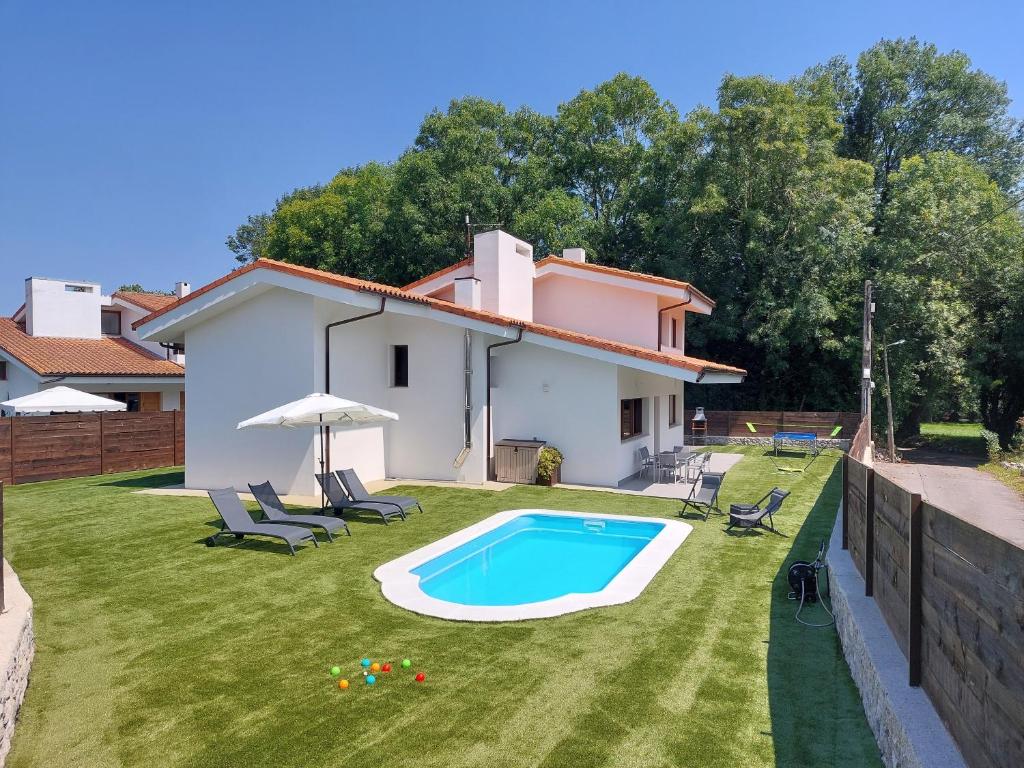 una casa con piscina en un patio en Vivienda Vacacional Villa Valdes en Llanes