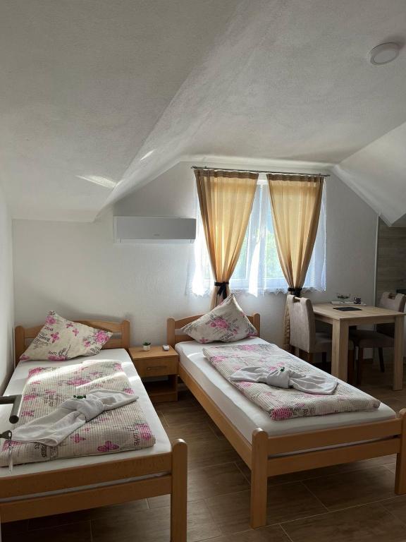 een slaapkamer met 2 bedden en een tafel met een tafel bij EDINA in Bihać