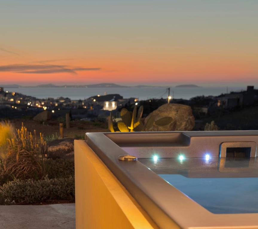 bañera de hidromasaje con puesta de sol en el fondo en Opuntia Suites, en Naxos Chora