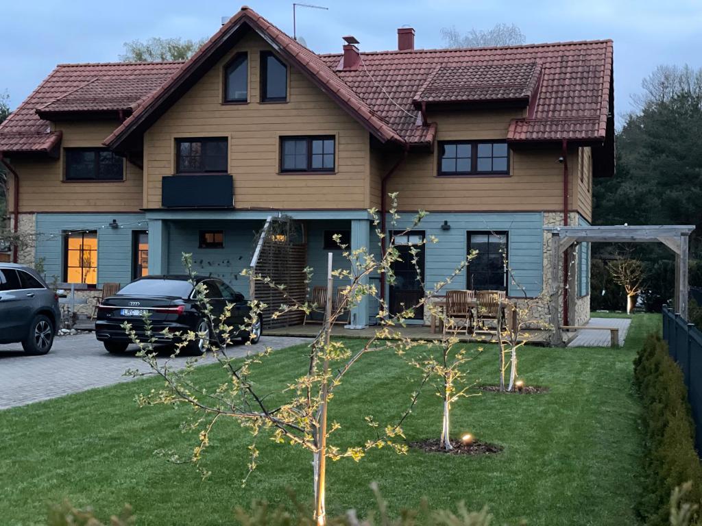 una casa con un coche aparcado delante de ella en Karkle SummerHOUSE, sea view villa, en Karklė