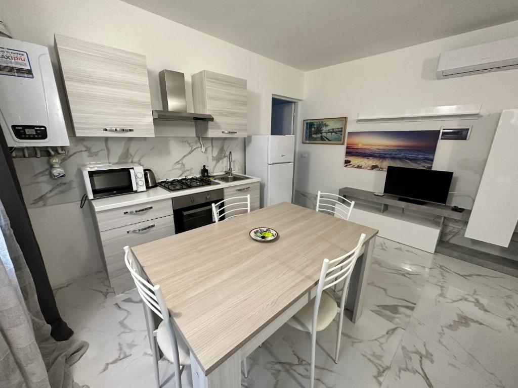 una cocina con mesa de madera y sillas. en Calle de le Pazienze Apartments en Venecia