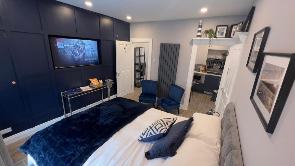 a bedroom with a large bed with a tv on the wall at The King's Parlour Whitehead in Whitehead