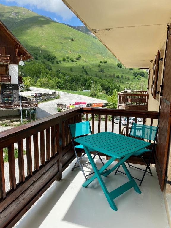 a blue table and chairs on a balcony with a view at Logement 4&#47;6 personnes à la montagne avec piscine in Saint-Sorlin-dʼArves