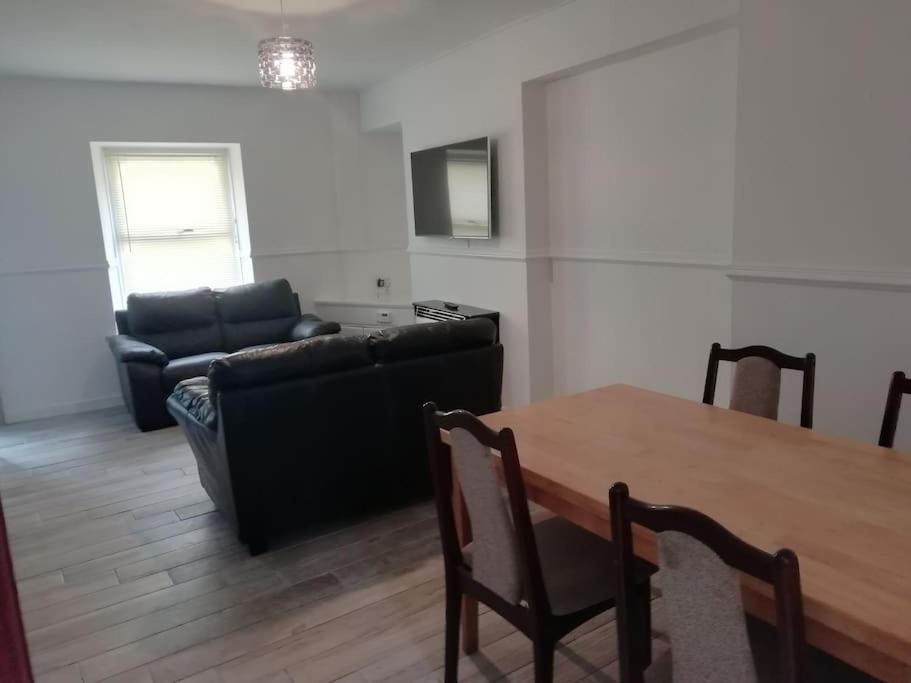 a living room with a table and a couch at Haverfordwest terraced home in Pembrokeshire
