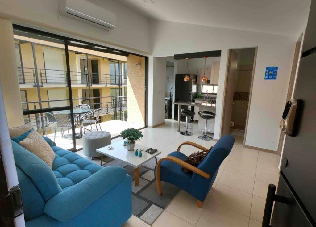 a living room with a blue couch and a table at Descanso y confort in La Tebaida