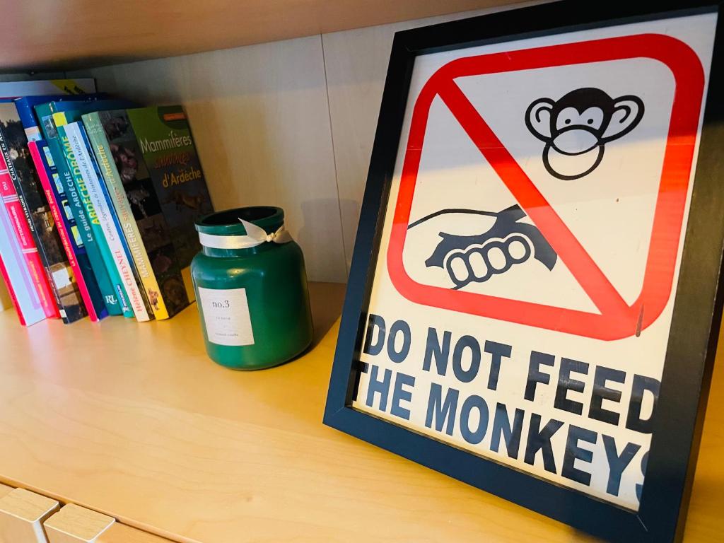 a sign that says do not feed the monkey on a shelf at Le Planzollais in Planzolles