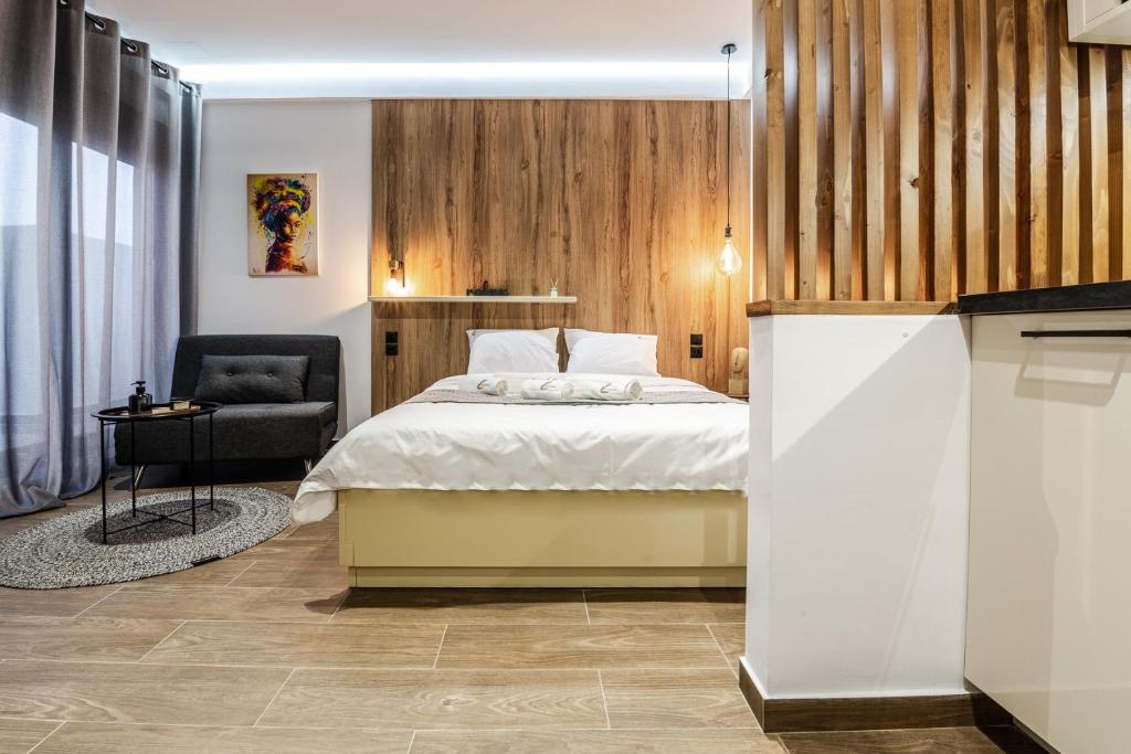 ein Schlafzimmer mit einem Bett und einem Stuhl in der Unterkunft Cinnamon in Volos