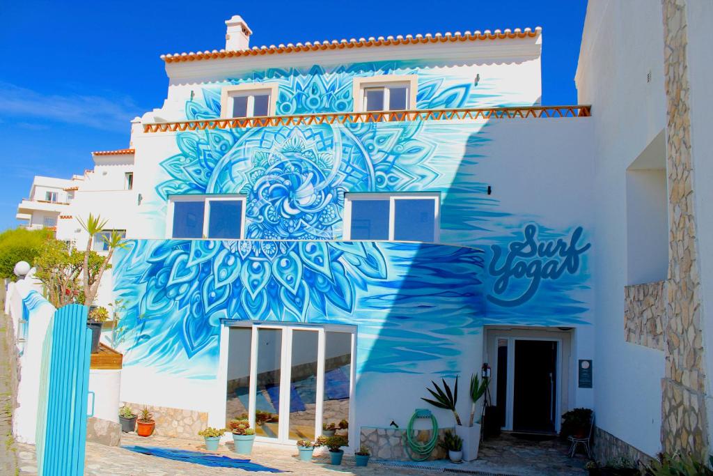 a building with a mural on the side of it at Surf Yoga Ericeira Guest House in Ericeira