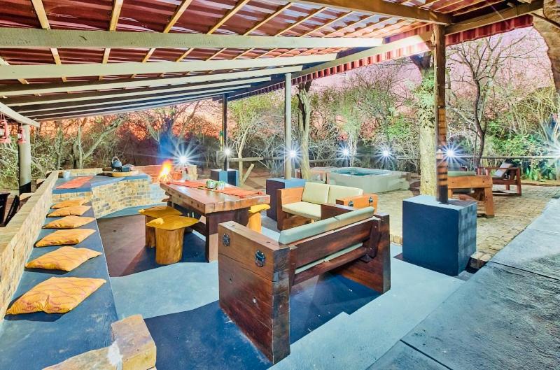un patio al aire libre con mesa y parrilla en Ostrich Cottage, en Marloth Park