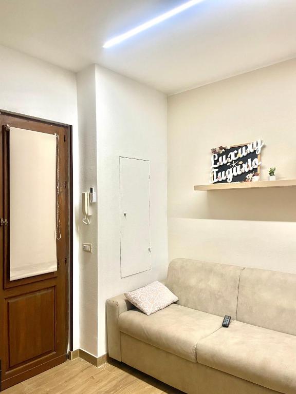 a living room with a couch and a sign on the wall at Luxury Tugurio in Arma di Taggia