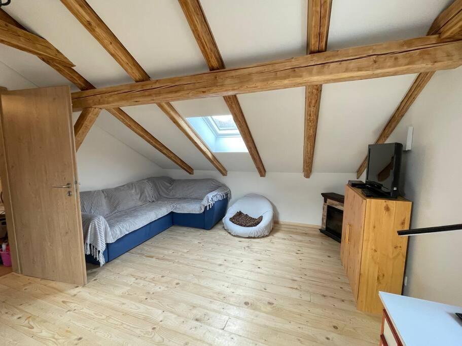 a room with a bed and a television in a attic at Ferienwohnung Aussicht, Monheimer Alb, Altmühltal 