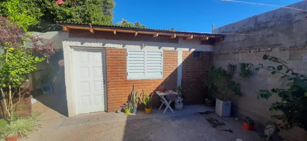 eine Garage mit einer weißen Tür und einer Ziegelwand in der Unterkunft DEPARTAMENTO MONOAMBIENTE in San Luis