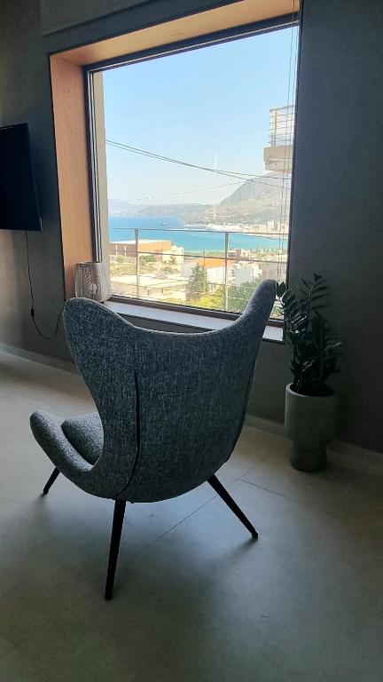 a chair sitting in front of a large window at Marigold Apartments in Chania Town