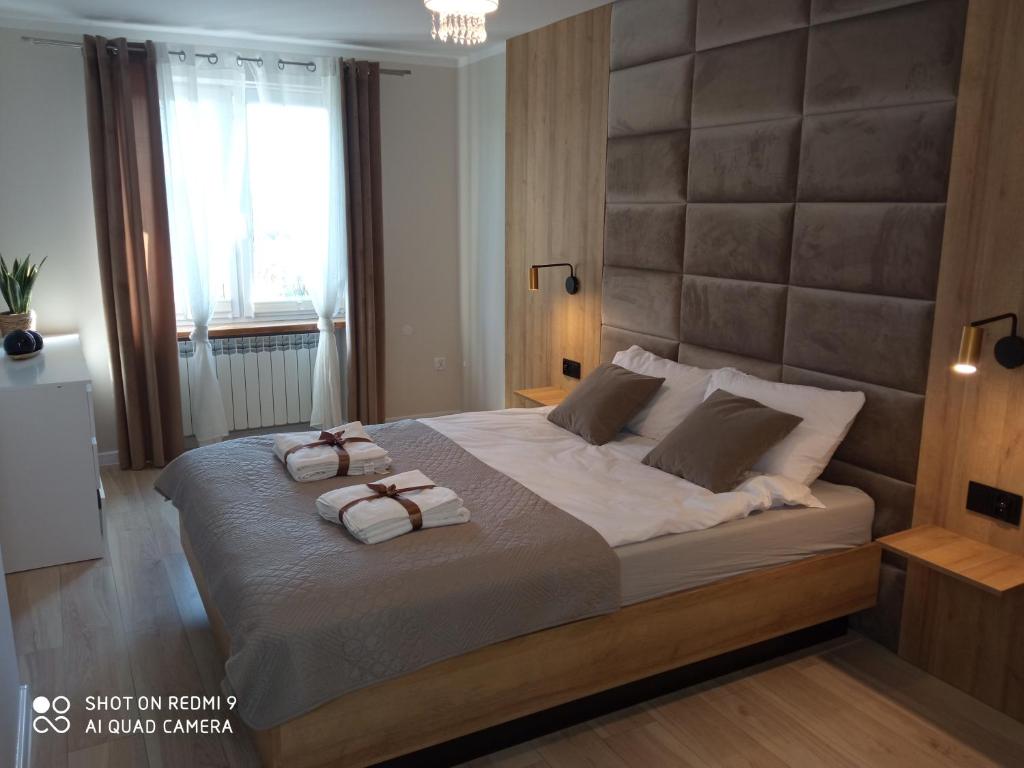 1 dormitorio con 1 cama grande y 2 toallas. en Apartament Storczyk, en Augustów