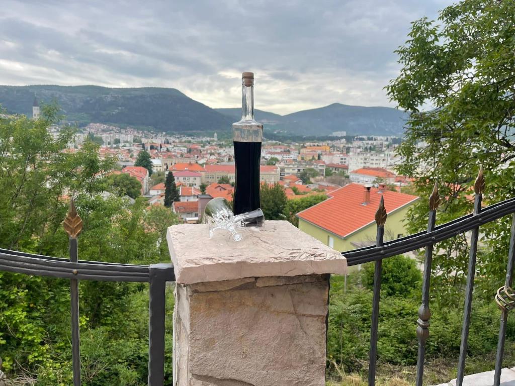- une bouteille de vin assise au-dessus d'un grand livre en pierre dans l'établissement Mostar View House, à Mostar
