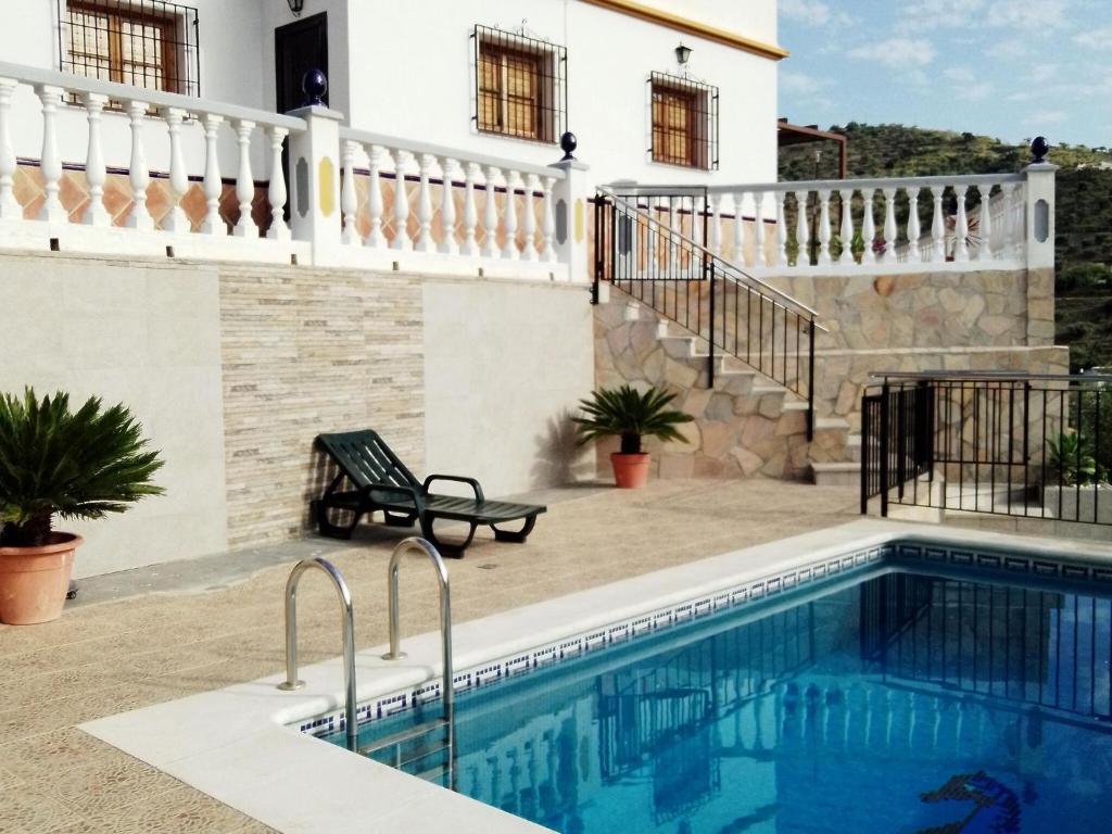 a swimming pool in front of a house at Belvilla by OYO Casa Granadillos in Málaga