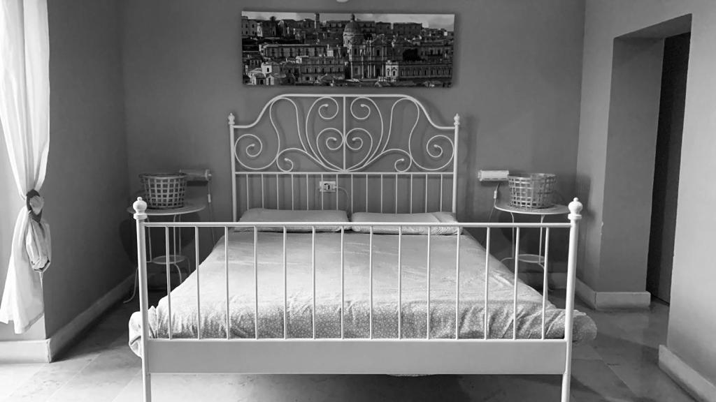 Una foto en blanco y negro de una cama en una habitación en Ostello della Gioventù - Il Castello en Noto