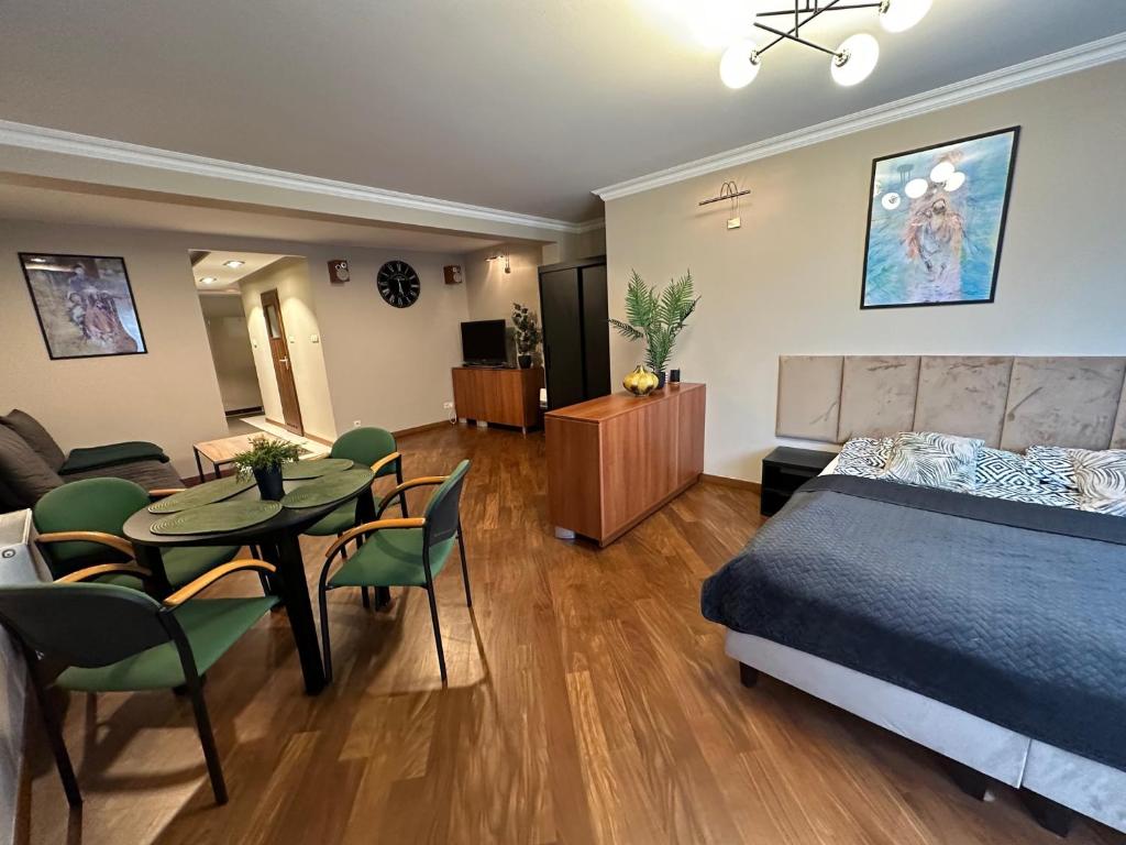 1 dormitorio con 1 cama, mesa y sillas en Venus Studio, en Zielona Góra