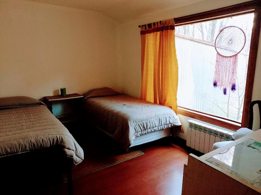 een slaapkamer met 2 bedden naast een raam bij Bosque Holístico del Fin del Mundo in Ushuaia