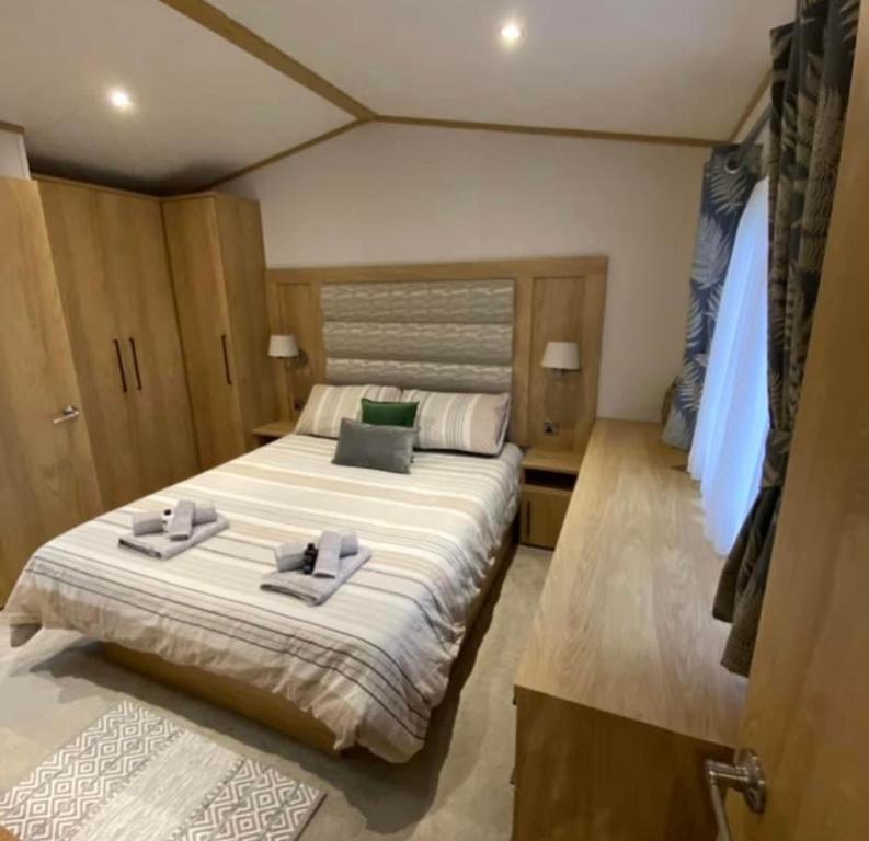 um quarto com uma cama grande e toalhas em Luxe Lodge em Ulrome