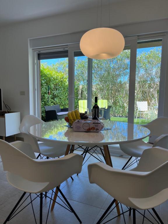 a dining room with a glass table and white chairs at Dream in Sibenik in Šibenik