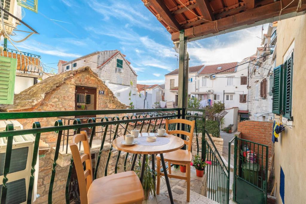 a balcony with a table and chairs on a city street at Apartments Jerolim in Split