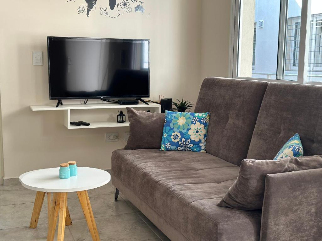 sala de estar con sofá y TV en Apartments Biritos en Godoy Cruz