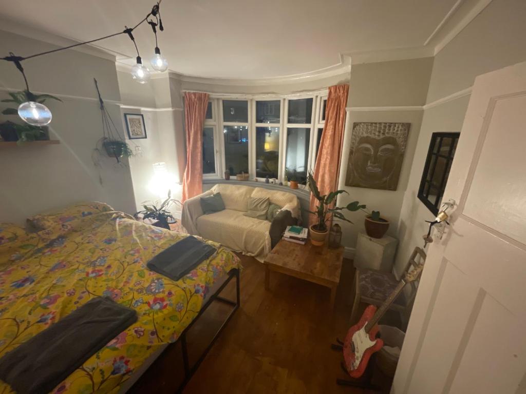 Birchfields Party House في مانشستر: غرفة نوم بسرير واريكة ونافذة
