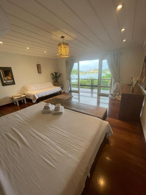 una grande camera da letto con un letto e una grande finestra di FERRADURA EXCLUSIVE SEaVIEW a Búzios