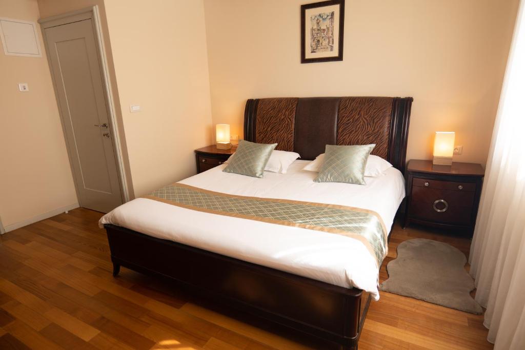 a bedroom with a large bed with two night stands at Scallop Regent Rooms in Zadar
