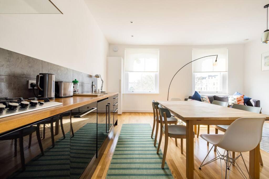 a kitchen with a wooden table and a green rug at The Perfect Portobello Loft in London